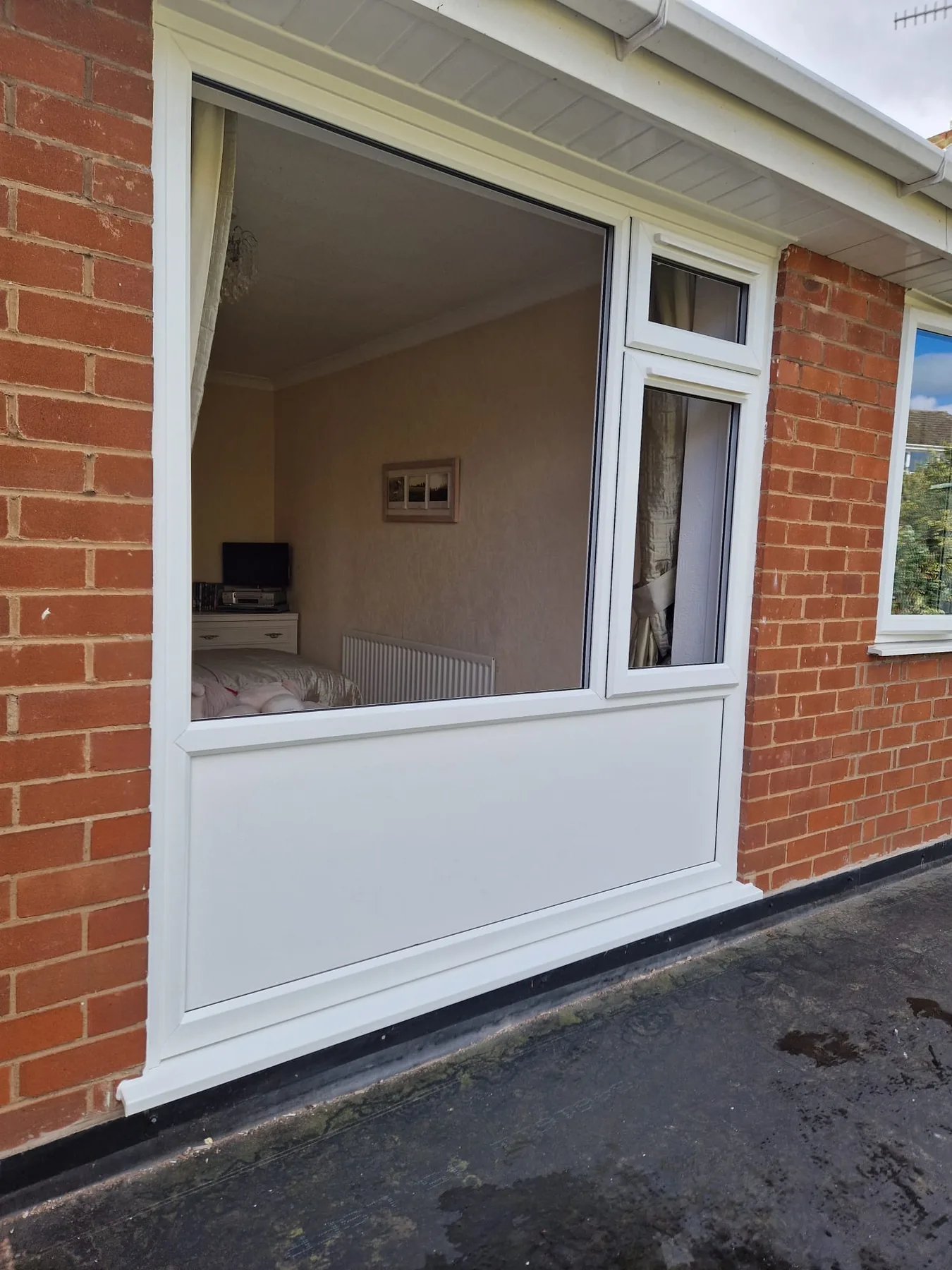 White combination window fitted into a red-brick home