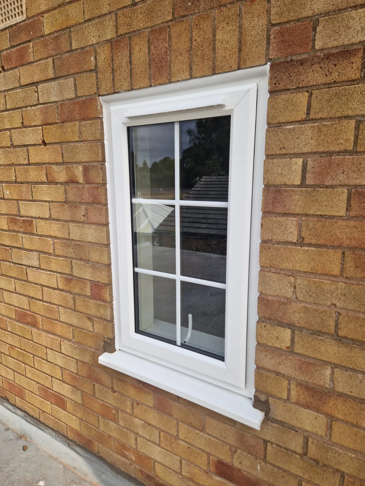 Close view of a white Georgian-bar casement window