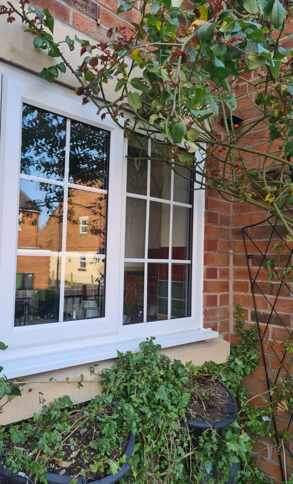 White Georgian-bar casement window beside a garden