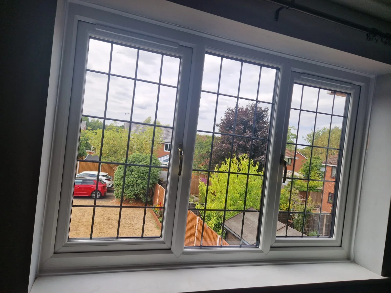 White window with square lead glazing overlooking a garden