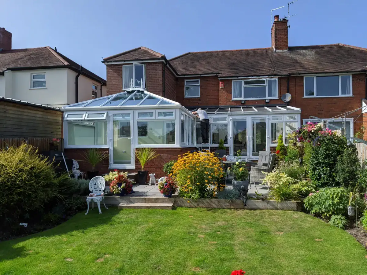 White conservatory installation overlooking a garden